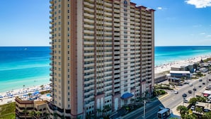 A high-rise hotel with multiple balconies overlooking a beach. - Gorgeous beachfront condo, shared pool and beach access (Panama City Beach)