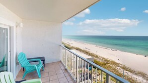 A balcony with turquoise chairs and a view of a beach. - Snowbird-friendly condo with panoramic beach & Gulf views - pools, gym (Panama City Beach)