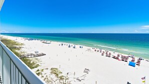 A beach with white sand, clear blue water, and a wooden pier. - Inviting Gulf-front condo In Perdido Key with waterfront pool/hot tub and oceanfront balcony (Perdido Key)
