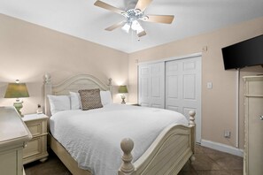 A bedroom with a bed, nightstands, a ceiling fan, a TV, and a wardrobe. - 2nd-floor, updated condo with Gulf-front views - short drive to shopping (Fort Walton Beach)