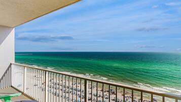 A balcony with a view of a beach and ocean.
