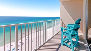 Un balcon avec vue sur une plage et l’océan.