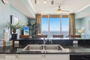 Une chambre d’hôtel avec une grande fenêtre, un lavabo et un ventilateur de plafond.
