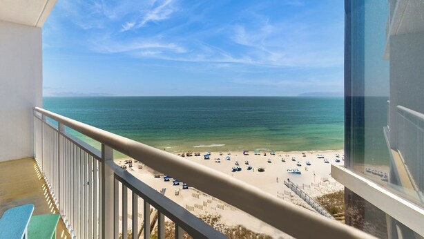 Een balkon met uitzicht op een strand en de oceaan.
