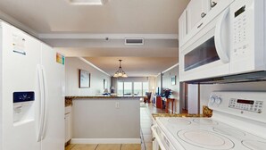 Une cuisine moderne dotée d’un îlot central, d’un four à micro-ondes encastré et d’une cuisinière.