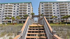 Un hôtel à plusieurs étages doté de balcons, d’une allée centrale et offrant une vue sur la plage.