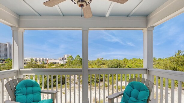 A covered porch with two turquoise chairs and a ceiling fan. - Airy townhouse with pool, hot tub, central AC, & washerdryer - dog-friendly (Perdido Key)