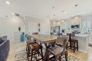 A modern kitchen with a central island, stainless steel appliances, and pendant lighting.