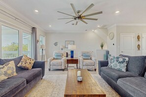 A living room with two sofas, a coffee table, and a ceiling fan.