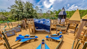 A playground with wooden play structures, slides, and a climbing area. - Home with kitchen, patio, playground, central AC, & W/D (Pensacola)