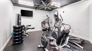 Ein Fitnessraum mit Laufbändern, Crosstrainern und Gewichte-Station.