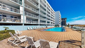 Ein Hotel mit Schwimmbad, mehreren Balkonen und Sitzbereichen im Freien.