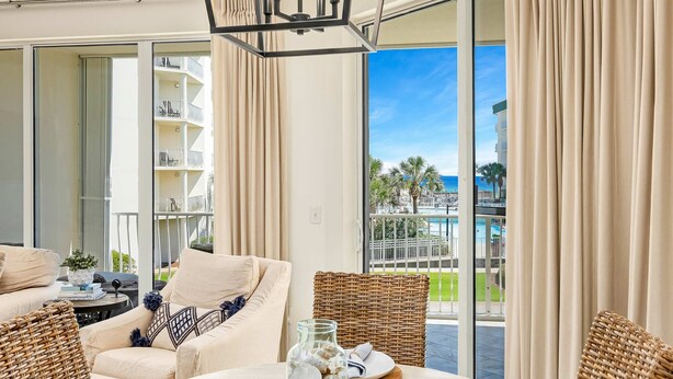 Een moderne hotelkamer met balkon, rieten meubilair en uitzicht op een resort.