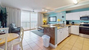 Een moderne keuken met een centraal eiland, witte kasten en roestvrijstalen apparatuur.
