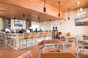 A spacious restaurant with high ceilings, wooden beams, and a mix of metal and wooden furniture. - Perdido Key Incredible Lake Views, Beach Chairs & Umbrella (Perdido Key)