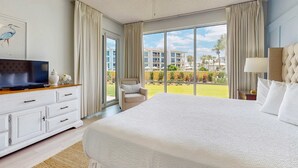 Une chambre d’hôtel avec un grand lit, une télévision, un bureau et une vue sur l’espace extérieur.