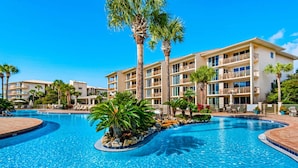 A hotel with a large swimming pool surrounded by palm trees and lounge chairs. - Gorgeous home with tennis, pickleball, pool & hot tub - steps from the beach (Seacrest)