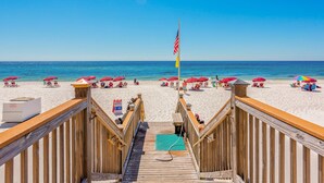 A wooden boardwalk leading to a beach with umbrellas and beach chairs. - Inviting Gulf-front condo In Perdido Key with waterfront pool/hot tub and oceanfront balcony (Perdido Key)