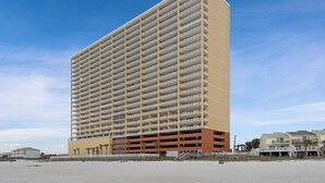 Un hotel moderno a più piani con balconi, situato vicino alla spiaggia.