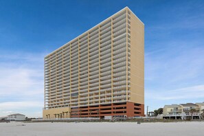 A high-rise hotel with multiple floors and balconies, situated near a beach. - Beachfront condo with pool & hot tub, near Pier Park (Panama City Beach)