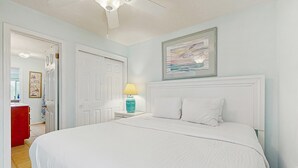 A bedroom with a large bed, a nightstand with a lamp, and a framed picture on the wall. - Family-friendly Gulf view condo with beach chair & umbrella, shared pool,hot tub (Miramar Beach)