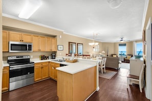 A modern kitchen with built-in appliances and wooden cabinets. - Gorgeous 3-bedroom condo with stunning view, spacious balcony & pickleball (Santa Rosa Beach)