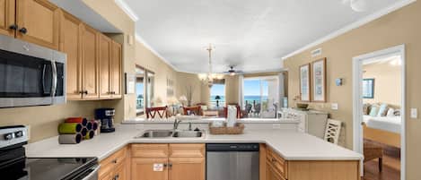 A modern kitchen with wooden cabinets, stainless steel appliances, and a central island.