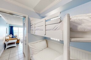 A room with bunk beds, a sofa, and a window with curtains. - Oceanfront Condo with Shared Pool, Ocean View, WiFi, Central AC, and Private W/D (Perdido Key)