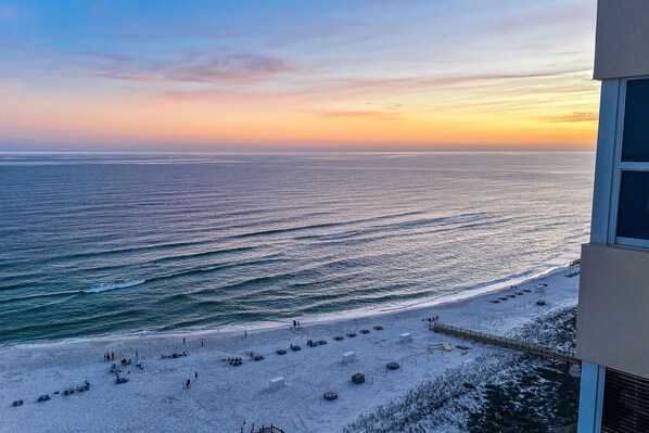 A beach with a view of the ocean and a building. - Oceanfront Condo with Shared Pool, Ocean View, WiFi, Central AC, and Private W/D (Perdido Key)