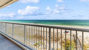 Ein Balkon mit Blick auf Strand und Meer.
