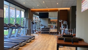 A gym with treadmills, weight machines, and dumbbells. - Sky Suites Mirage (Accra)