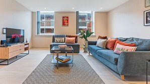 A modern living room with a sofa, coffee table, and TV. - The Chic Escape in Leeds (Leeds)