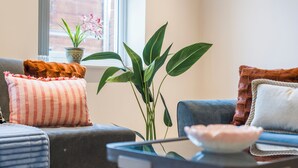A living room with a sofa, a coffee table, and a potted plant. - The Chic Escape in Leeds (Leeds)