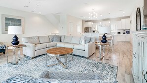 Ein modernes Wohnzimmer mit einem Ecksofa, einem Couchtisch und einem gemusterten Teppich.