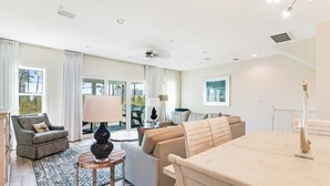 Ein geräumiges Wohnzimmer mit einer Couch, einem Sessel und einem Esstisch.