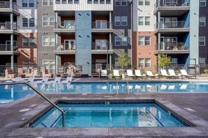 A modern apartment building with a swimming pool and lounge chairs. - Landing | Spectacular 1BD, Pool, Gym (Colorado Springs)