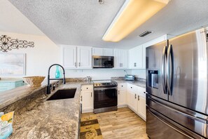 A modern kitchen with white cabinets, stainless steel appliances, a microwave, oven, and a large refrigerator. - 3rd-floor beachfront condo with Gulf views, pool, gym, balcony, W&D, central AC (Fort Walton Beach)