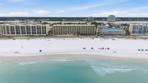 A beach with a hotel in the background.