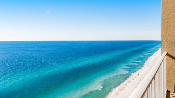 A beach view from a balcony with a clear sky. - Spacious Gulf front condo w/shared hot tub, pools, gym - close to dining (Panama City Beach)