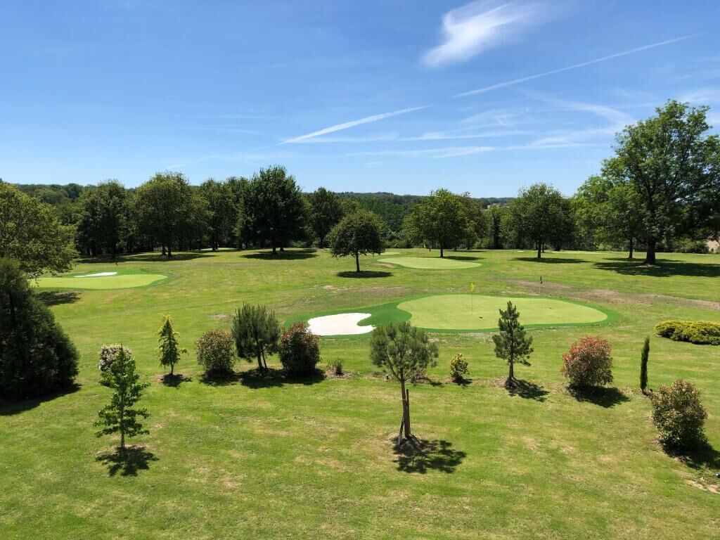 Un parcours de golf doté de plusieurs greens, de bunkers de sable et d’arbres.