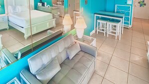 Ein Hotelzimmer mit einem Bett, einer Couch, einem Esstisch mit Stühlen und einem Spiegel.