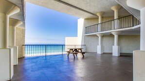 Ein geräumiger Balkon mit Meerblick, ausgestattet mit einer Holzbank und einem Geländer.