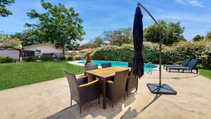 Um quintal com piscina, móveis de exterior e um pergolado.