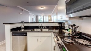 A modern kitchen with a dishwasher, stove, and sink. - Welcoming, Coastal Condo On Okaloosa Island Playground, 2 Hot Tubs (Fort Walton Beach)