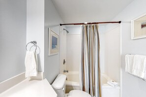 Une salle de bain avec une douche, des toilettes et un porte-serviettes.
