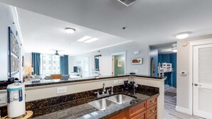 Una cocina moderna con encimera de granito, pileta doble y muebles de madera.