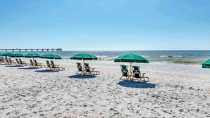 A beach with rows of green umbrellas and lounge chairs. - Exquisite, Gulf-front, 1st-floor condo At Waterscape Waterfall, lazy river (Fort Walton Beach)