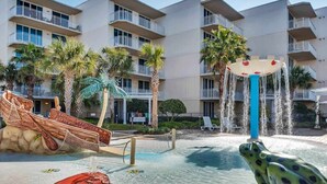 A pool area with a frog statue, a water fountain, and a boat-themed play structure. - Exquisite, Gulf-front, 1st-floor condo At Waterscape Waterfall, lazy river (Fort Walton Beach)