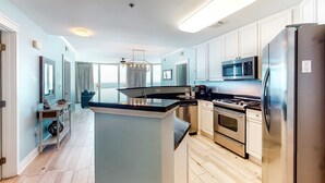 A modern kitchen with white cabinets, stainless steel appliances, and a central island. - Exquisite, Gulf-front, 1st-floor condo At Waterscape Waterfall, lazy river (Fort Walton Beach)