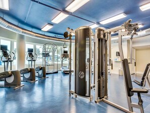 A gym with various exercise equipment, large windows, and a blue ceiling. - Spacious, Beach-Chic Condo At Waterscape Steps To Beach Lazy River (Fort Walton Beach)